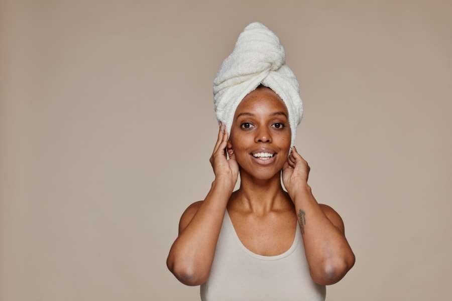 Femme avec une serviette sur la tête incarnant la fraîcheur du maquillage "no makeup".