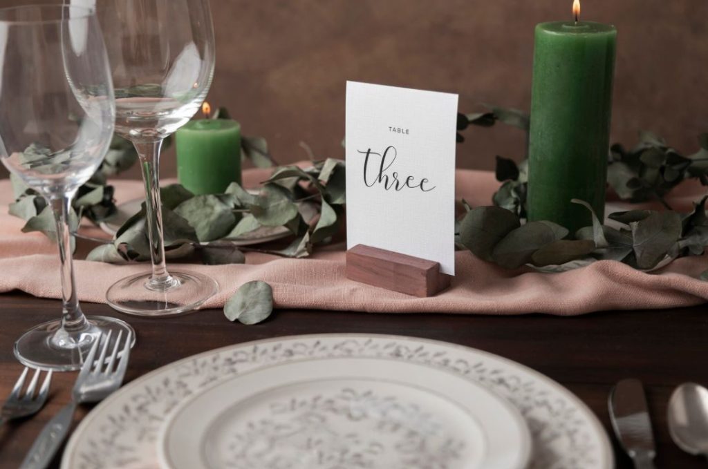 Numéro de table calligraphié sur socle en bois pour une création papeterie sur mesure mariage élégante et végétale.